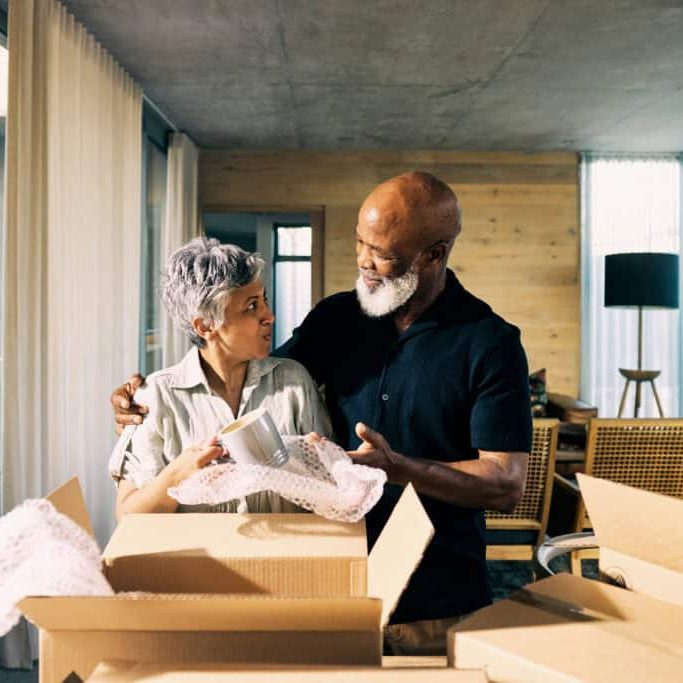 generation x african american couple unpacking memories and smiling in new home during retirement transition